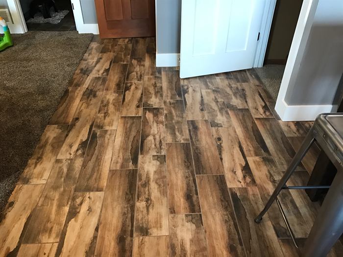 Brown wood look plank tile in a staggered layout running down a hallway