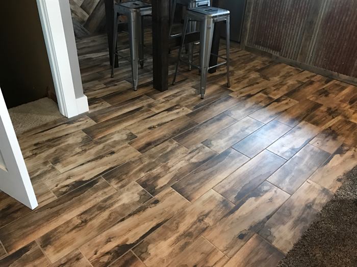 Brown wood look plank tile floor in a dining area with metal bar stools
