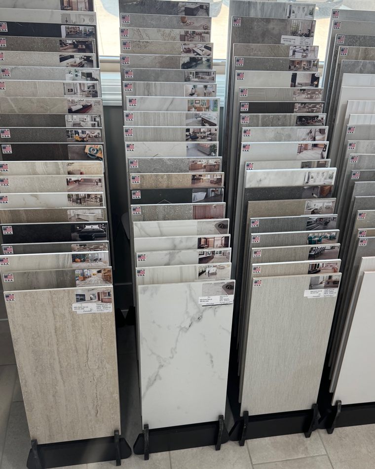 Showroom racks of large format porcelain tile samples in marble, stone and linear looks
